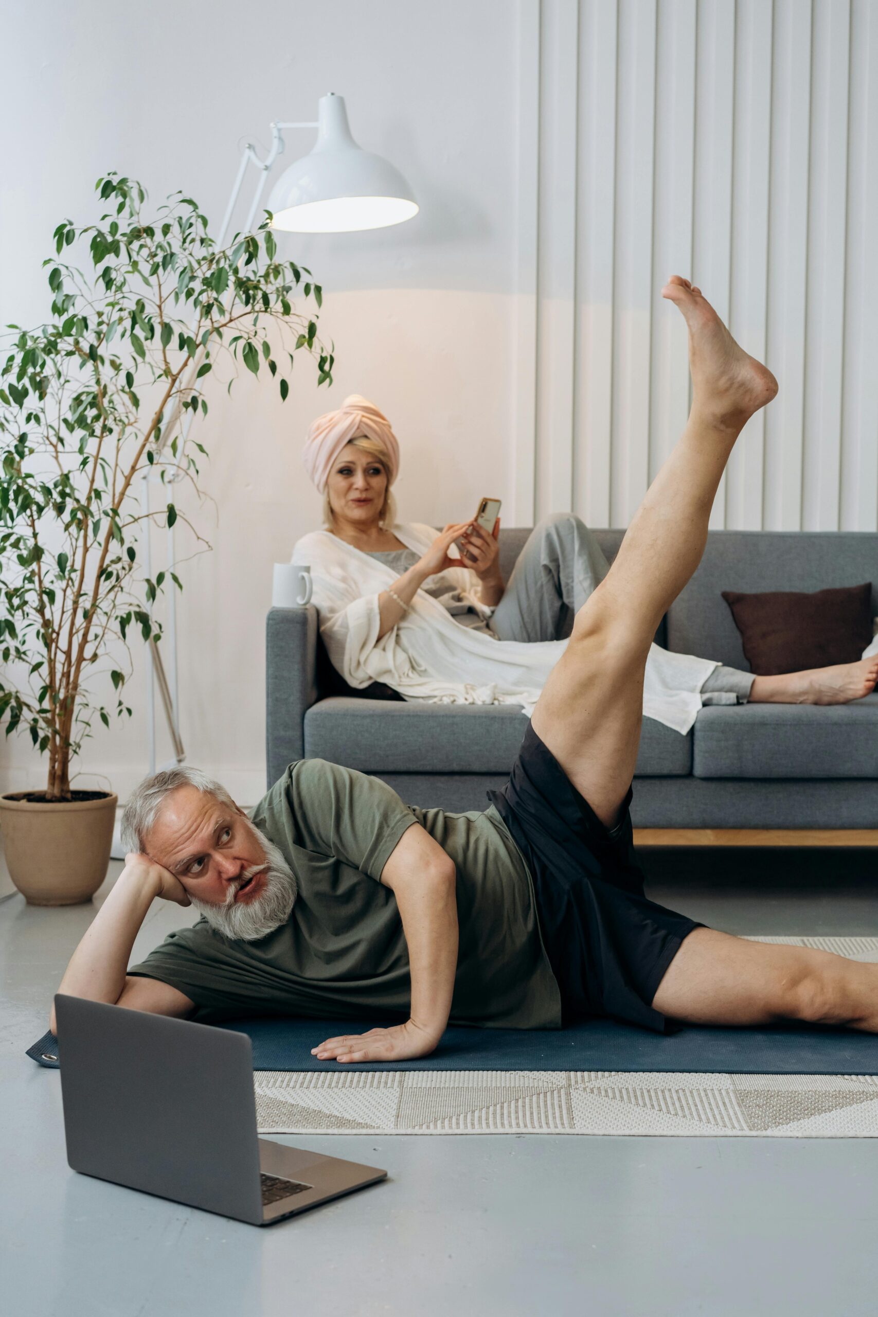 A man performing a plank exercise at home, demonstrating proper form with a straight line from head to heels, engaging his core, shoulders, and back muscles.